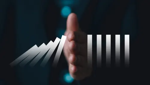 A hand stopping a rising line of metallic bars, symbolizing halting growth or a barrier to progress in a business context